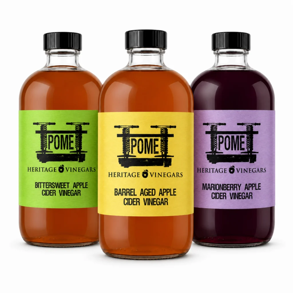 The three POME vinegars side by side: Bittersweet with a green label, Barrel Aged with a yellow label, and Marionberry with a lavender label.